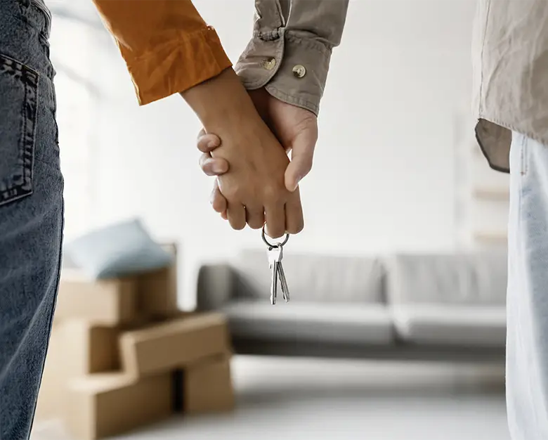 Paar hält Schlüssel beim Einzug in die neue Wohnung.