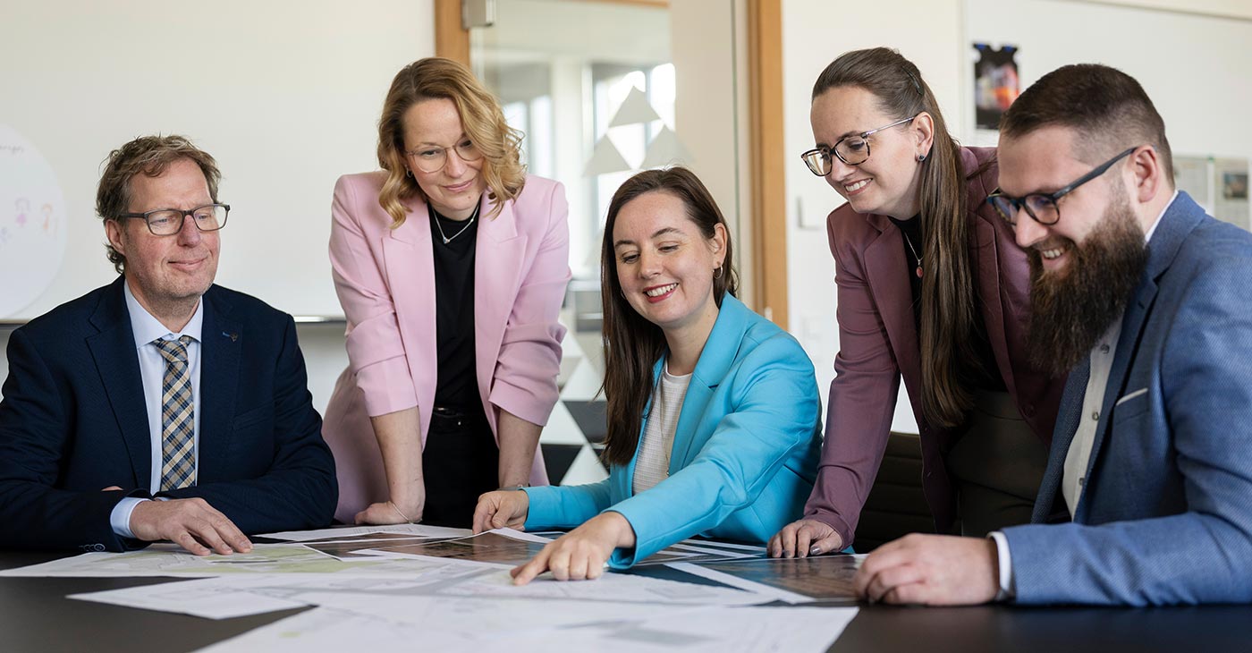 Mitarbeitende besprechen Unterlagen am Arbeitsplatz.